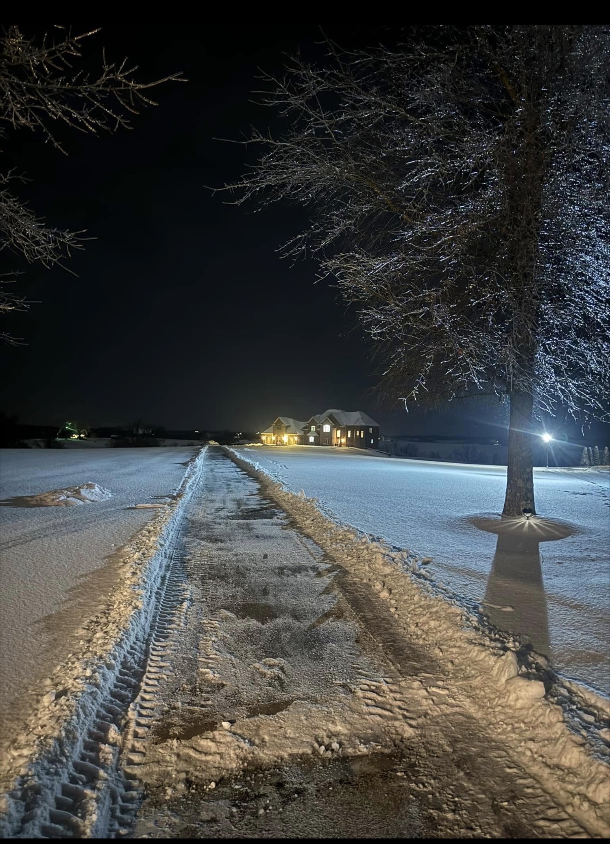 Snow-cleared residential driveway photographed at night