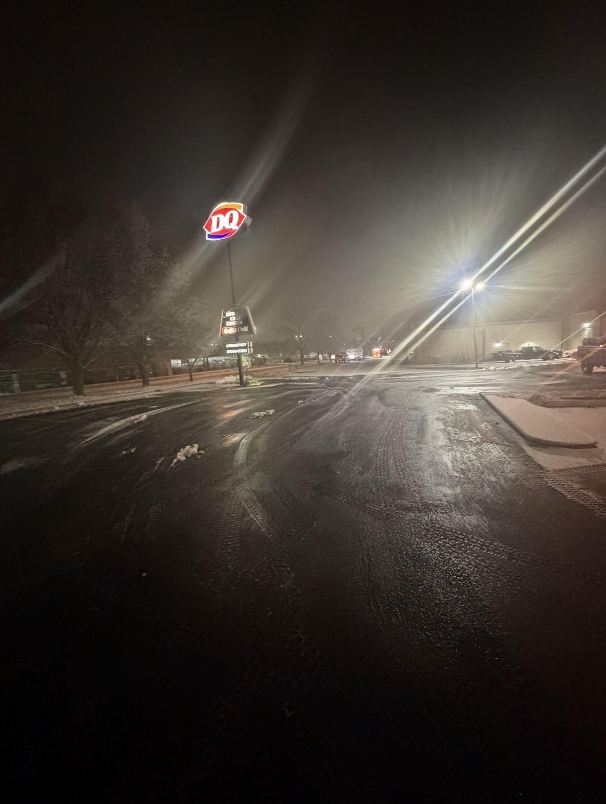 Snow-cleared Dairy Queen parking lot at night