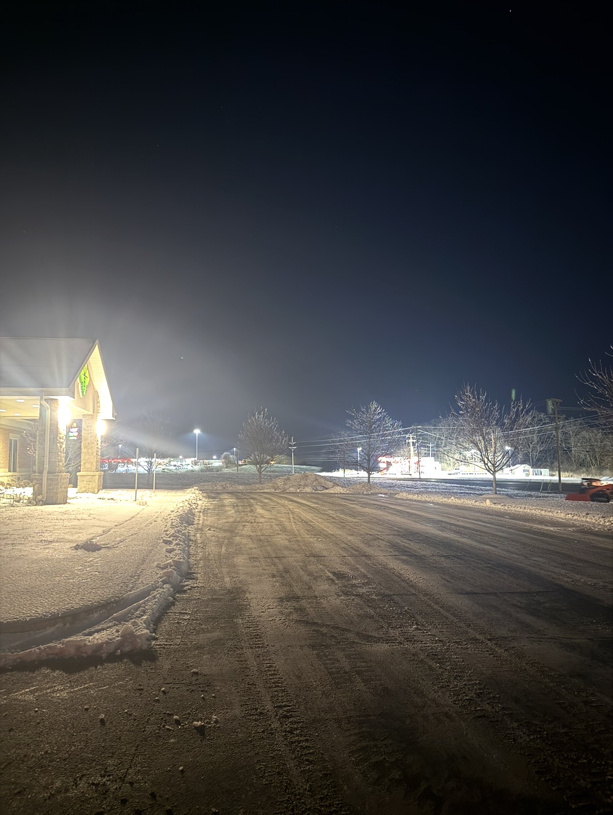 Restaurant parking lot during nighttime snow removal
