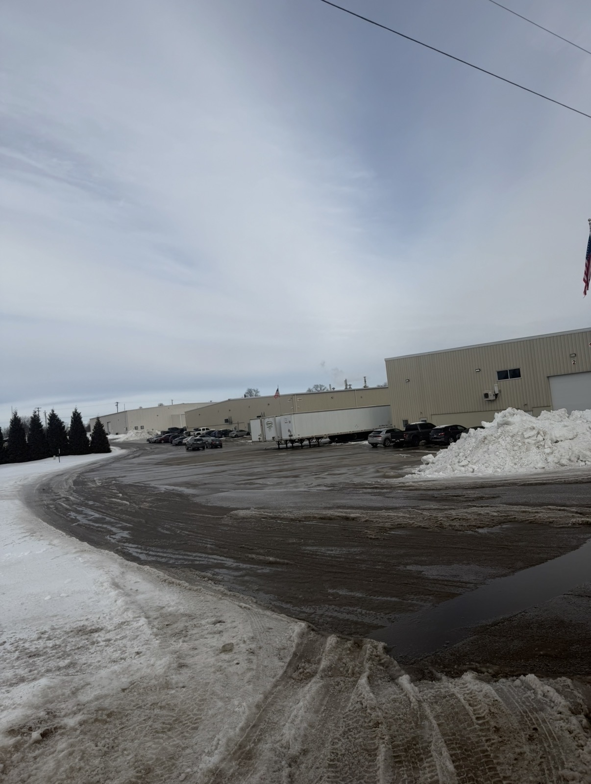 Cleared industrial parking lot with snow piled along the edge